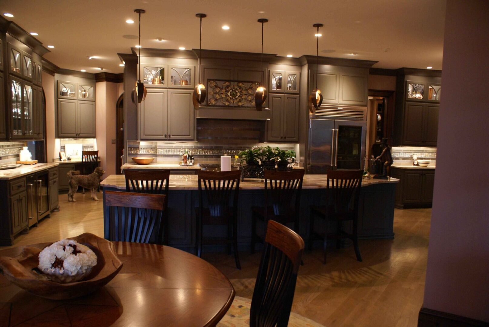 A kitchen with a large island and wooden chairs.