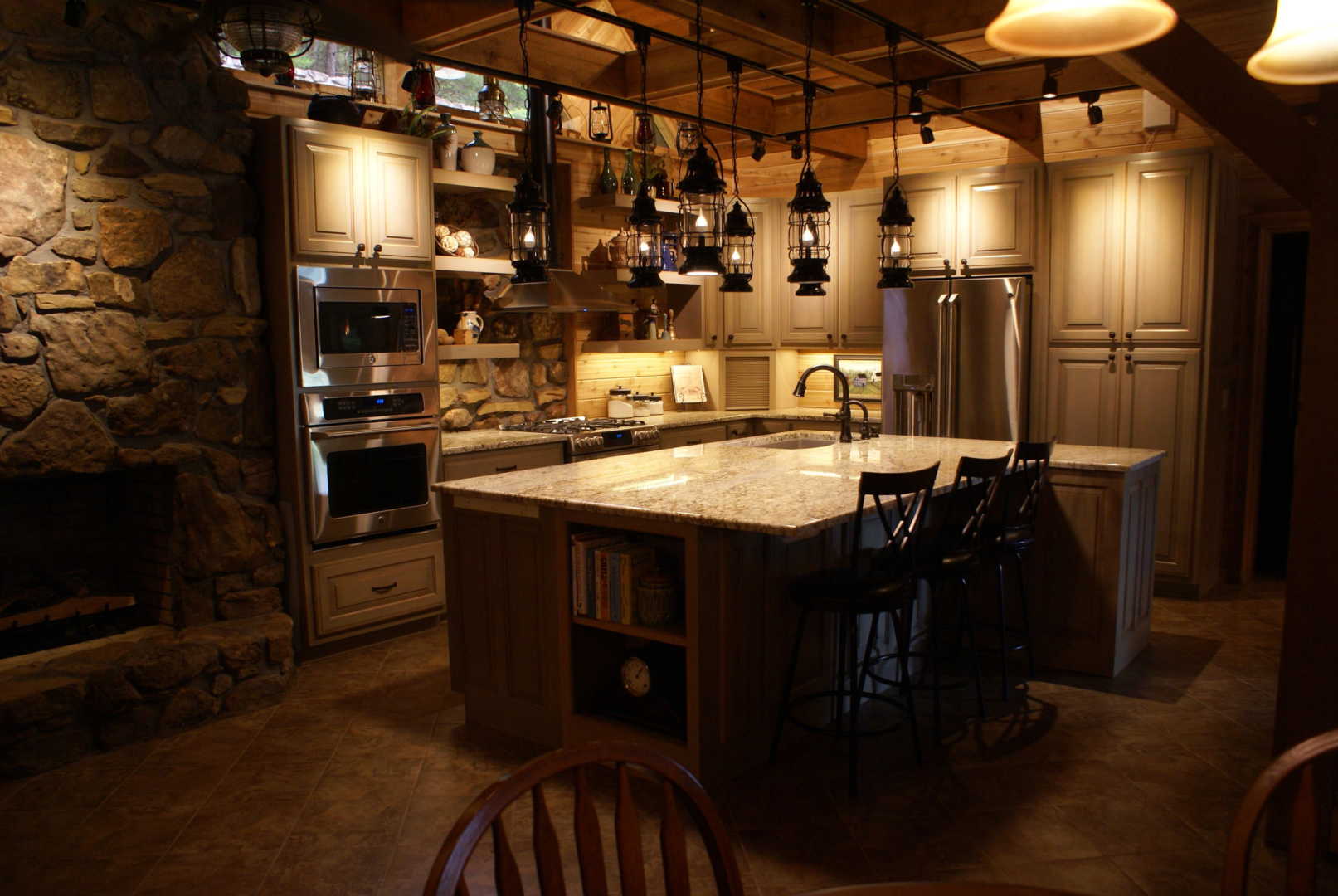 A kitchen with an island and many lights.